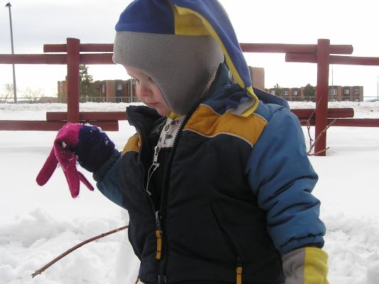 Noah is working on a snowman. 
He likes to wear my pink and purple gloves.