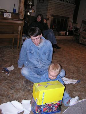 Noah opens a present from great grandma and great grandpa.