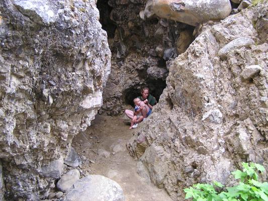 Katie and Noah are hiding in a small cave.