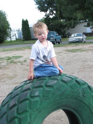 Noah on a green tire. 