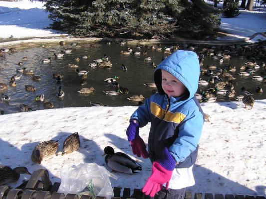 Noah is happy feeding the ducks.
