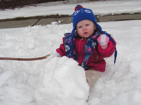 Sarah is sitting in the snow.