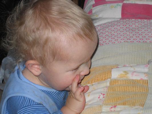Noah looks at the kitty on the bed.