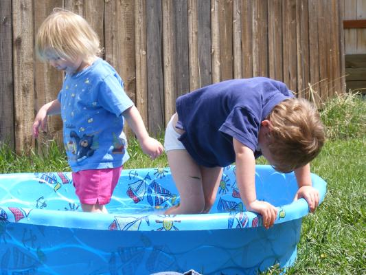 Sarah and Noah play in the pool.