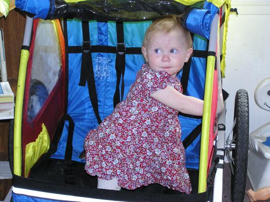 Sarah climbs in the bike trailer.