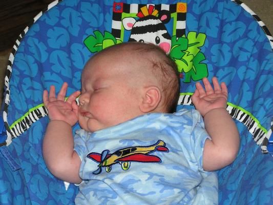 Noah sleeps whith his hands by his head.
