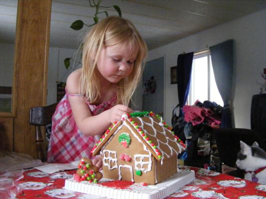 Sarah decorates the gingerbread house.