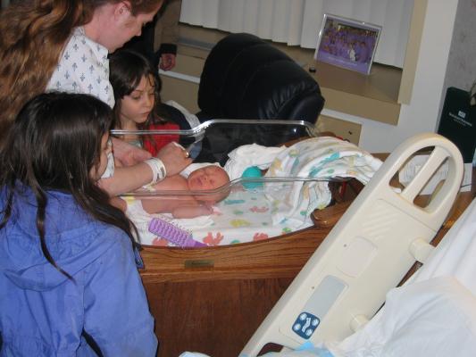Katie shows Malia and Andrea the new baby.