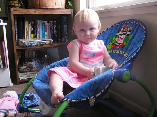 Sarah in her cheerleading outfit sitting in her chair.