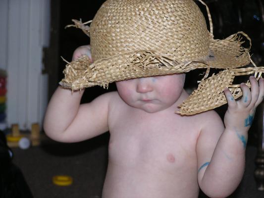 Noah plays with an old straw hat.