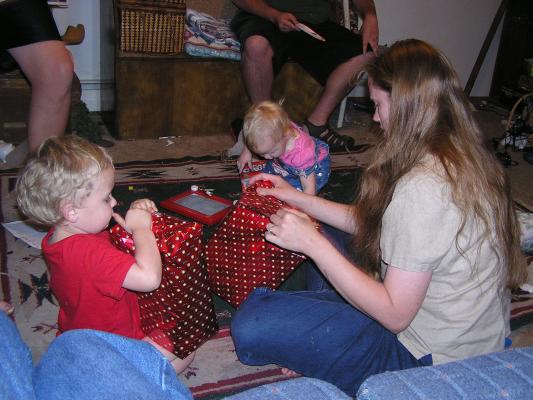 Katie, Noah and Sarah open gifts