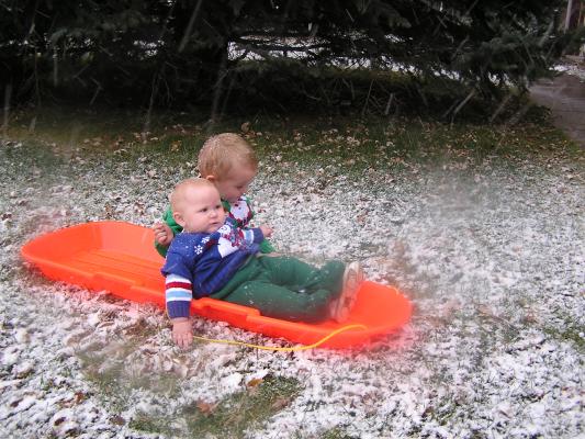 Sarah and Noah get pictures on a sled.