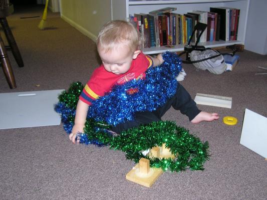 Noah plays with green and blue tinsel.