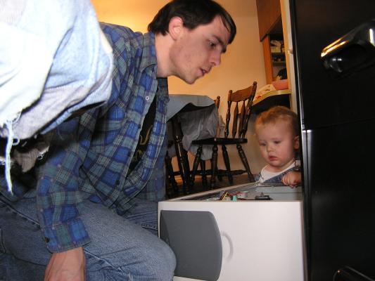 Noah helps daddy fix the computer.