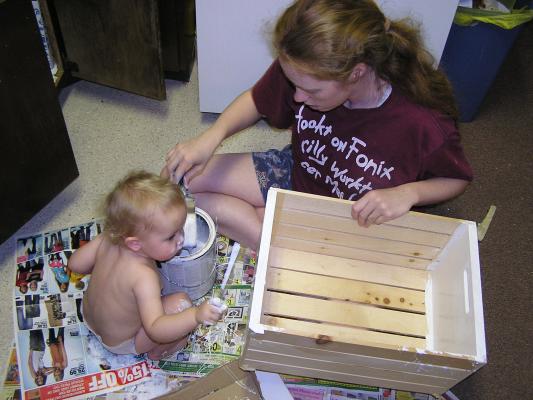 Noah and Katie are painting a wooden box.