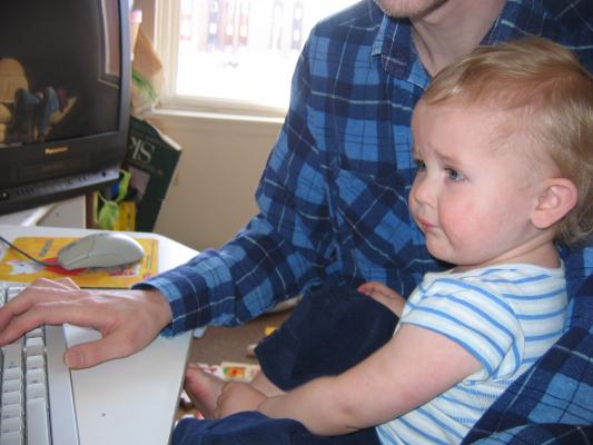 Noah plays computer with his daddy.