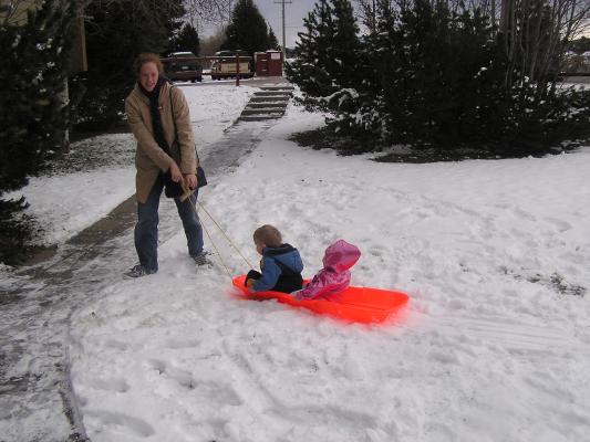 Noah and Sarh ride in the sled.