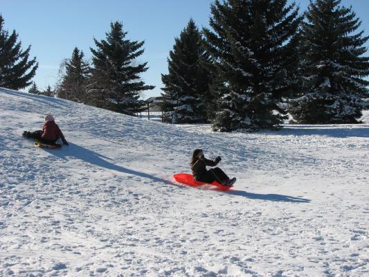 Andrea and Malia sledding.