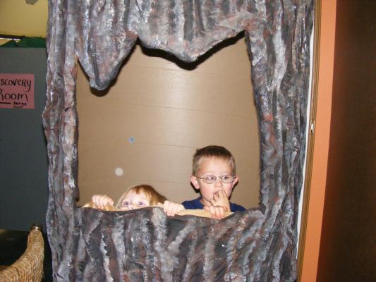 Sarah and Noah play in a fake tree.