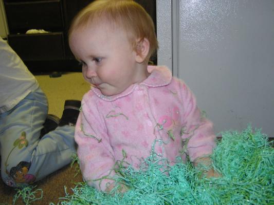 Sarah plays with Easter grass.