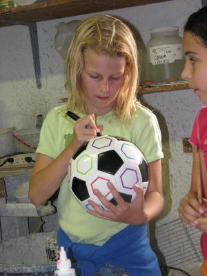 Kala signing the soccer ball.