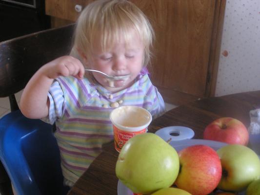 Sarah is eating peach yogurt.