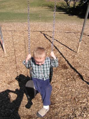 Noah swings at the park.
