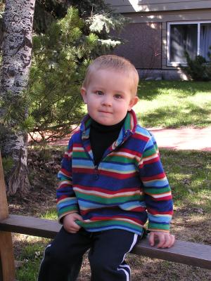 Noah sits on the arm of the bench.