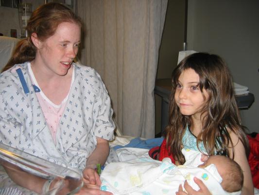 Andrea holds Sarah on the hospital bed.