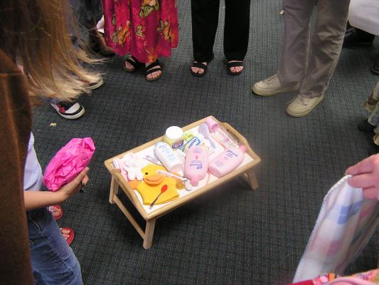 Everyone stands around memorizing all of the baby items.