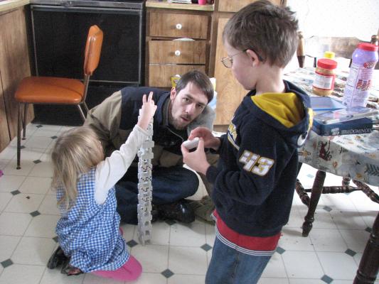 Sarah, David and Noah stack the dominoes.