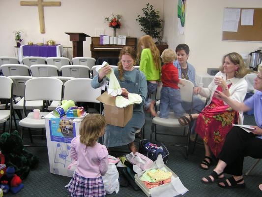 Katie opens presents at Sarah's baby shower.