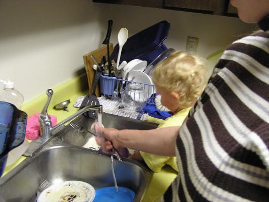 Noah wanted to wash dishes, so Katie decided to help him.