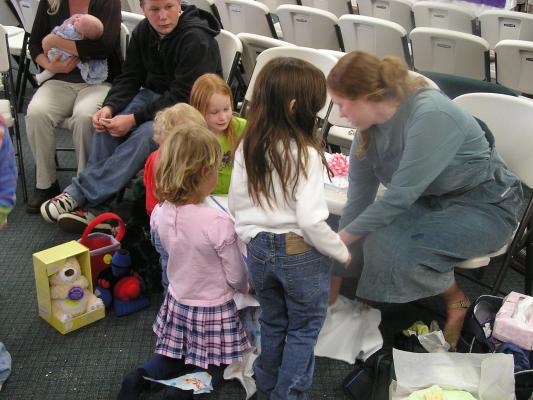 The kids all gather around to watch the presents being opened.