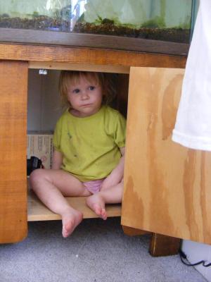 Sarah in a cupboard under the fish tank.