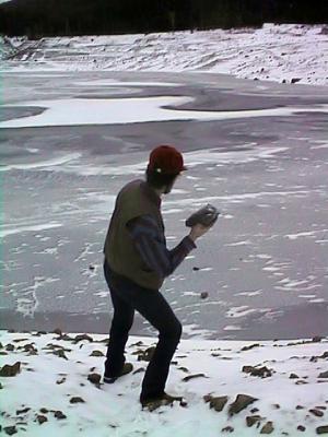 Dad throughs rocks at the ice.